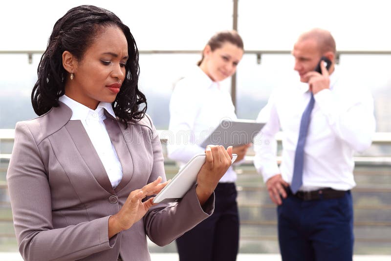 Hombre de negocios africano de la empresaria que sostiene un al aire libre derecho disponible de la tableta imagenes de archivo Hombre de negocios africano de la empresaria que sostiene un al aire libre derecho disponible de la tableta imagenes de archivo