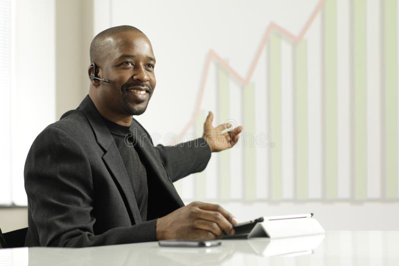 Hombre de negocios afroamericano que presenta beneficios foto de archivo libre de regalías Hombre de negocios afroamericano que presenta beneficios foto de archivo libre de regalías