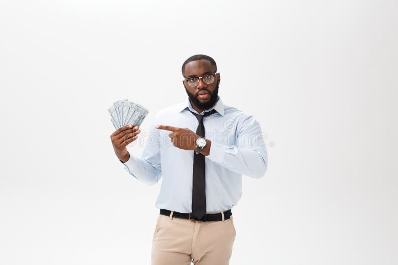 Hombre de negocios afroamericano que sostiene efectivo y en la cámara de mirada seria Interior, aislado en fondo gris fotos de archivo libres de regalías Hombre de negocios afroamericano que sostiene efectivo y en la cámara de mirada seria Interior, aislado en fondo gris fotos de archivo libres de regalías