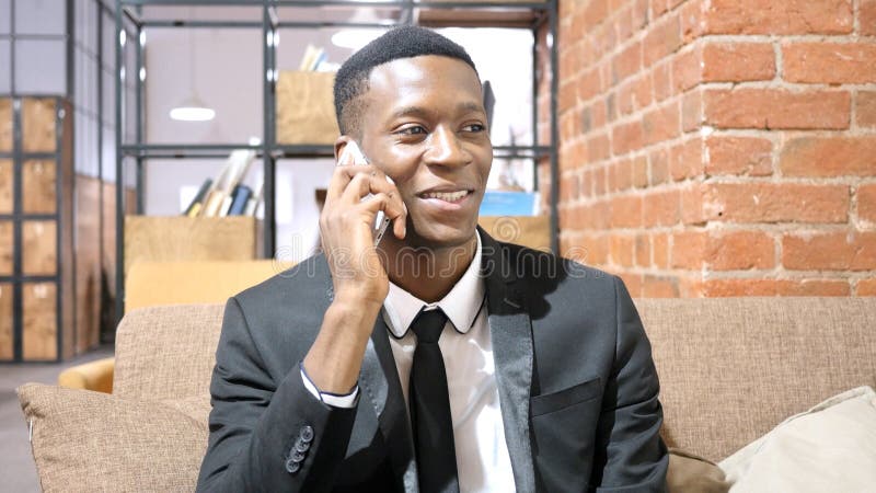 Hombre de negocios afroamericano Talking On Smartphone imagen de archivo Hombre de negocios afroamericano Talking On Smartphone imagen de archivo