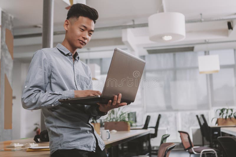 Hombre de negocios asi?tico joven que trabaja en la oficina foto de archivo Hombre de negocios asi?tico joven que trabaja en la oficina foto de archivo