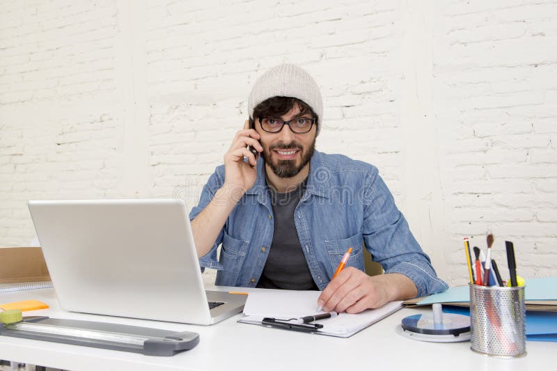 Hombre de negocios atractivo hispánico del inconformista que trabaja en casa la oficina usando el teléfono móvil fotos de archivo libres de regalías