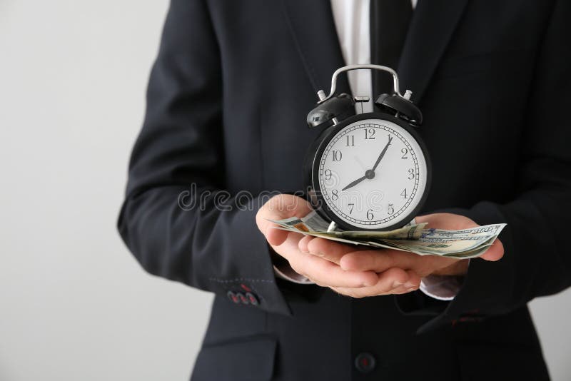 Hombre de negocios con el reloj y el dinero en el fondo ligero, primer fotografía de archivo libre de regalías Hombre de negocios con el reloj y el dinero en el fondo ligero, primer fotografía de archivo libre de regalías