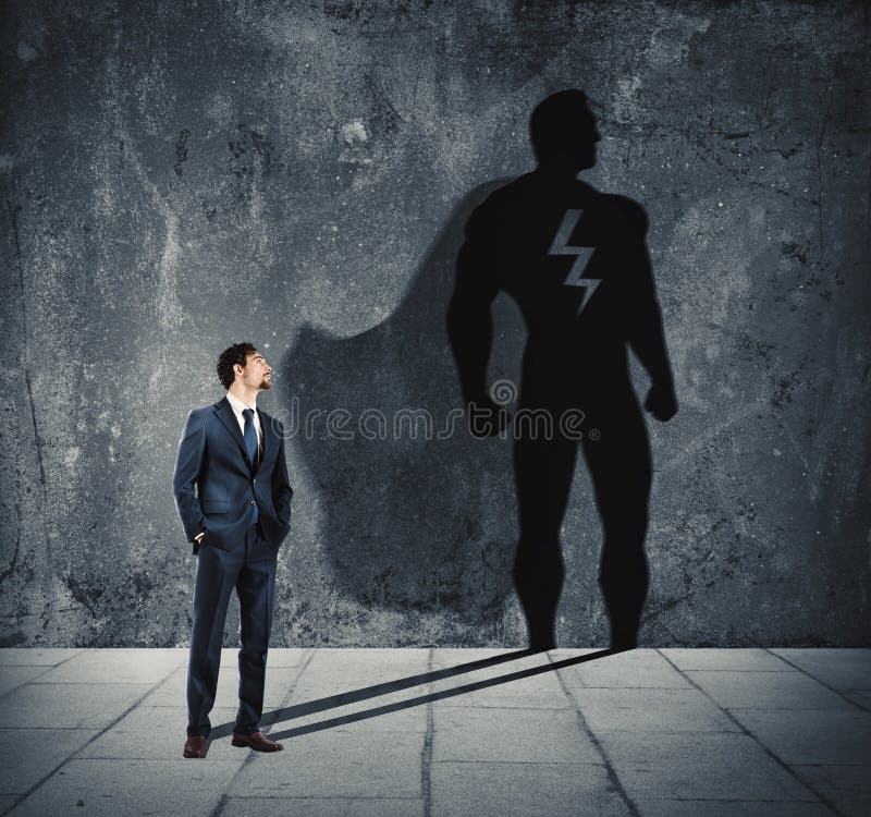 Hombre de negocios con su sombra del superhéroe en la pared Concepto de hombre potente fotos de archivo libres de regalías Hombre de negocios con su sombra del superhéroe en la pared Concepto de hombre potente fotos de archivo libres de regalías
