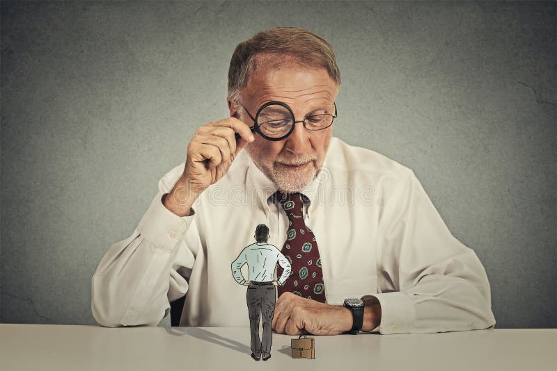 Hombre de negocios corporativo que mira a través de la lupa el empleado imagen de archivo libre de regalías Hombre de negocios corporativo que mira a través de la lupa el empleado imagen de archivo libre de regalías