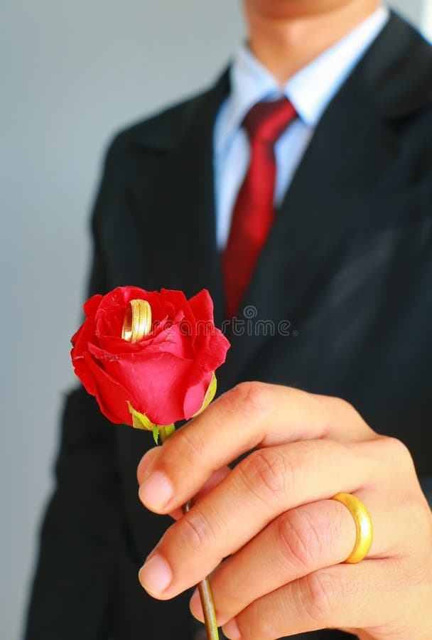 Hombre de negocios en la demostración del traje color de rosa y el anillo de bodas foto de archivo libre de regalías Hombre de negocios en la demostración del traje color de rosa y el anillo de bodas foto de archivo libre de regalías