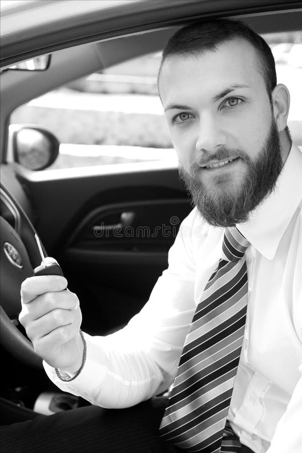Hombre de negocios feliz con el nuevo coche que sostiene el retrato blanco y negro de las llaves fotos de archivo Hombre de negocios feliz con el nuevo coche que sostiene el retrato blanco y negro de las llaves fotos de archivo
