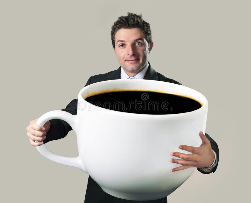 Hombre de negocios feliz que lleva a cabo la taza de gran tamaño enorme divertida de cof negro imagen de archivo Hombre de negocios feliz que lleva a cabo la taza de gran tamaño enorme divertida de cof negro imagen de archivo