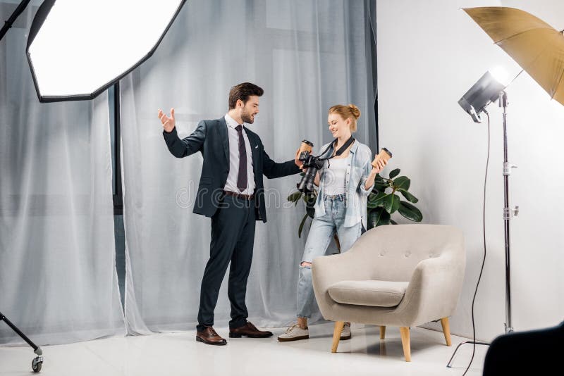 hombre de negocios feliz que sostiene el café para ir y que habla con el fotógrafo foto de archivo libre de regalías hombre de negocios feliz que sostiene el café para ir y que habla con el fotógrafo foto de archivo libre de regalías