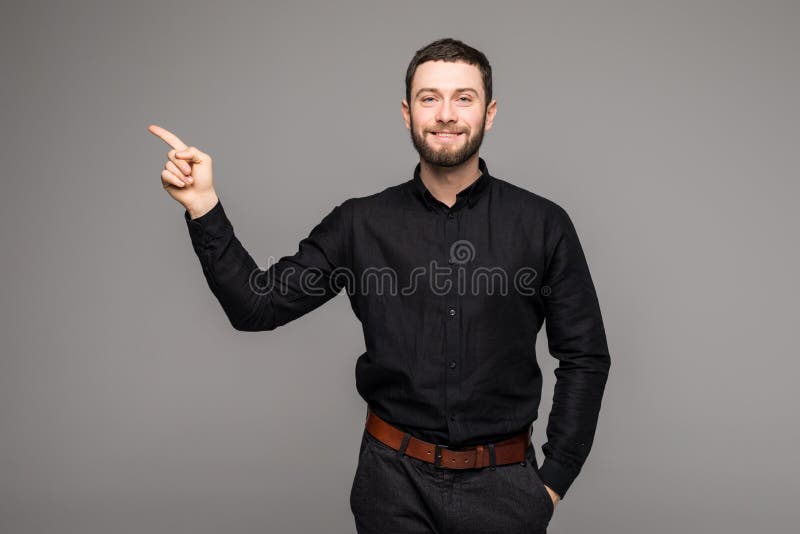 Hombre de negocios hermoso joven con sonrisa de emisión que señala con el finger fotografía de archivo libre de regalías Hombre de negocios hermoso joven con sonrisa de emisión que señala con el finger fotografía de archivo libre de regalías