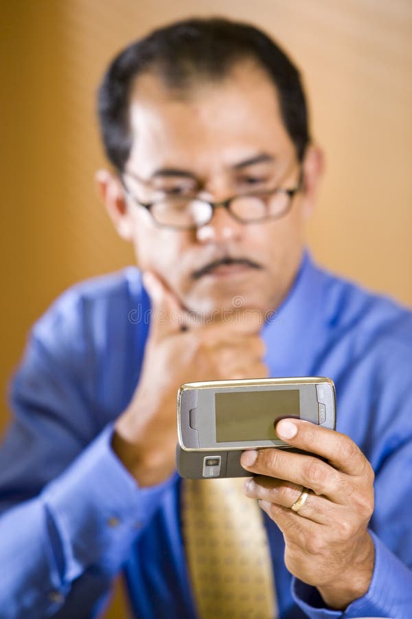 Hombre de negocios hispánico de mediana edad texting fotografía de archivo