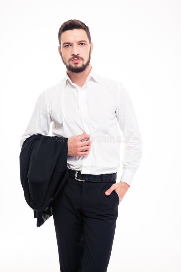 Hombre de negocios joven confiado hermoso con la barba que coloca y que sostiene la chaqueta fotos de archivo libres de regalías Hombre de negocios joven confiado hermoso con la barba que coloca y que sostiene la chaqueta fotos de archivo libres de regalías