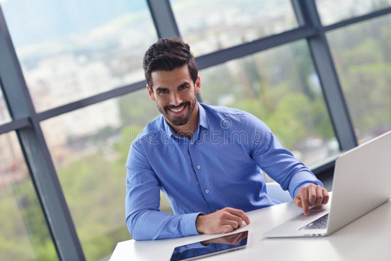 Hombre de negocios joven feliz en la oficina imagen de archivo Hombre de negocios joven feliz en la oficina imagen de archivo
