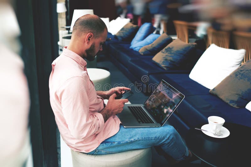 Hombre de negocios joven que espera a su socio comercial en un café foto de archivo Hombre de negocios joven que espera a su socio comercial en un café foto de archivo