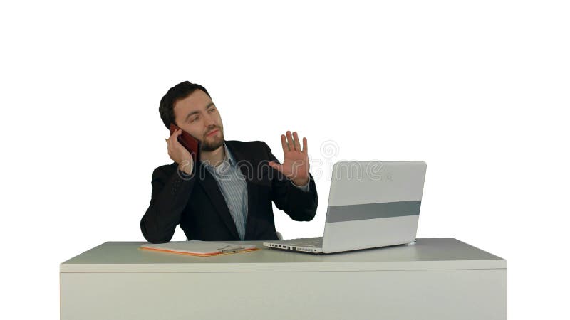 Hombre de negocios joven que habla en el teléfono en oficina En el fondo blanco aislado imagen de archivo libre de regalías Hombre de negocios joven que habla en el teléfono en oficina En el fondo blanco aislado imagen de archivo libre de regalías