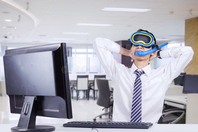 Hombre de negocios joven que se imagina sus vacaciones imágenes de archivo libres de regalías Hombre de negocios joven que se imagina sus vacaciones imágenes de archivo libres de regalías