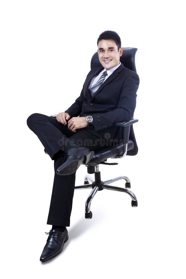 Hombre de negocios joven que se sienta en la silla - aislada imagen de archivo Hombre de negocios joven que se sienta en la silla - aislada imagen de archivo