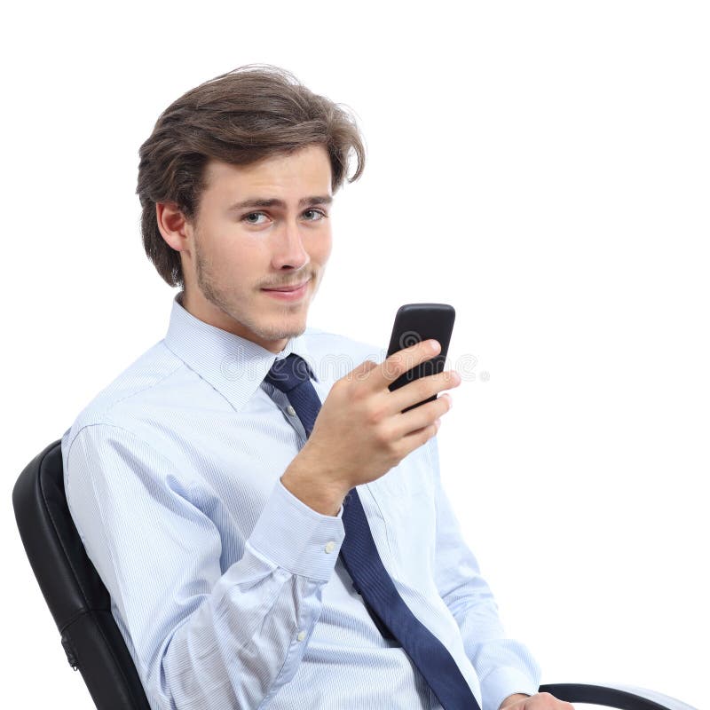 Hombre de negocios joven que se sienta en una silla usando un teléfono elegante fotos de archivo libres de regalías Hombre de negocios joven que se sienta en una silla usando un teléfono elegante fotos de archivo libres de regalías