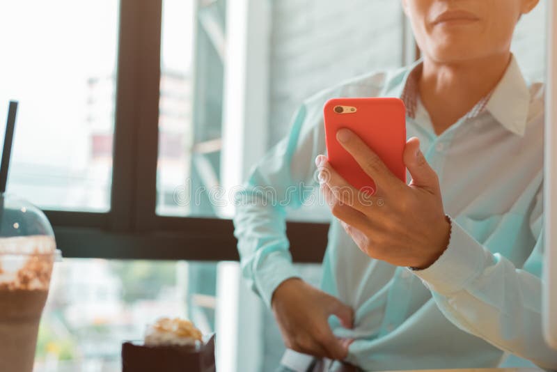 Hombre de negocios joven que trabaja en una cafetería que comprueba su teléfono imagen de archivo libre de regalías Hombre de negocios joven que trabaja en una cafetería que comprueba su teléfono imagen de archivo libre de regalías
