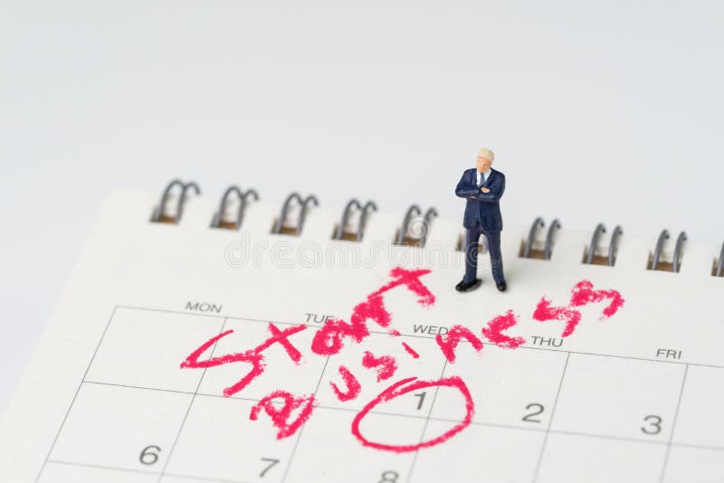 Hombre de negocios miniatura con la confianza que se coloca en el calendario blanco con el círculo en negocio del comienzo de la imagenes de archivo Hombre de negocios miniatura con la confianza que se coloca en el calendario blanco con el círculo en negocio del comienzo de la imagenes de archivo