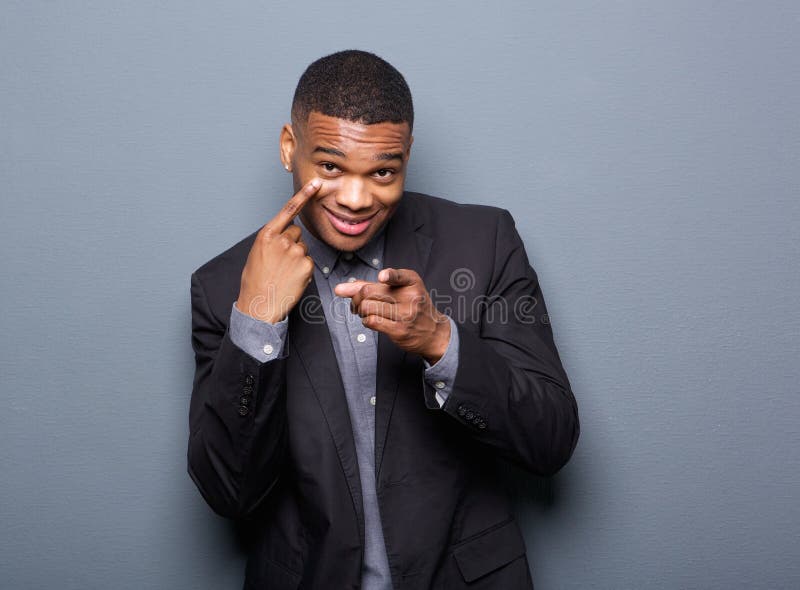 Portrait of a black business man pointing finger to eye and at you. Portrait of a black business man pointing finger to eye and at you