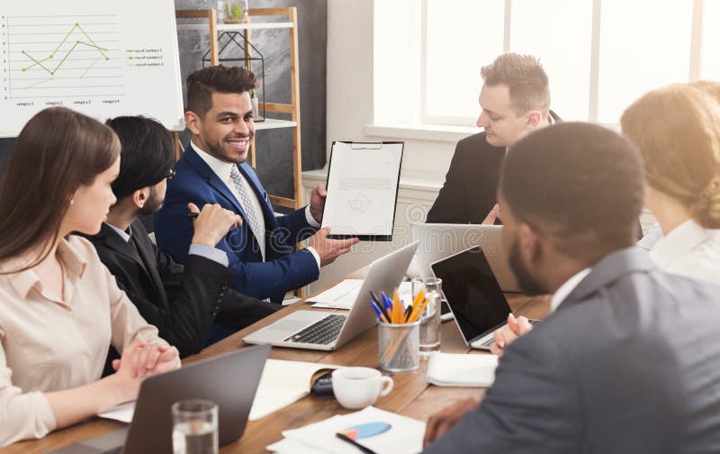 Hombre de negocios que muestra informe anual a sus colegas foto de archivo Hombre de negocios que muestra informe anual a sus colegas foto de archivo