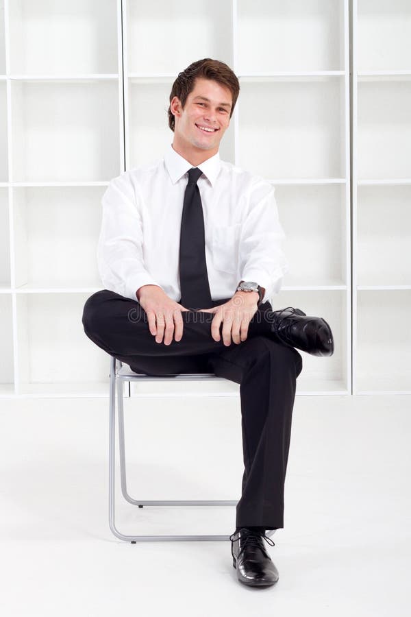 Hombre de negocios que se sienta en silla imagen de archivo Hombre de negocios que se sienta en silla imagen de archivo
