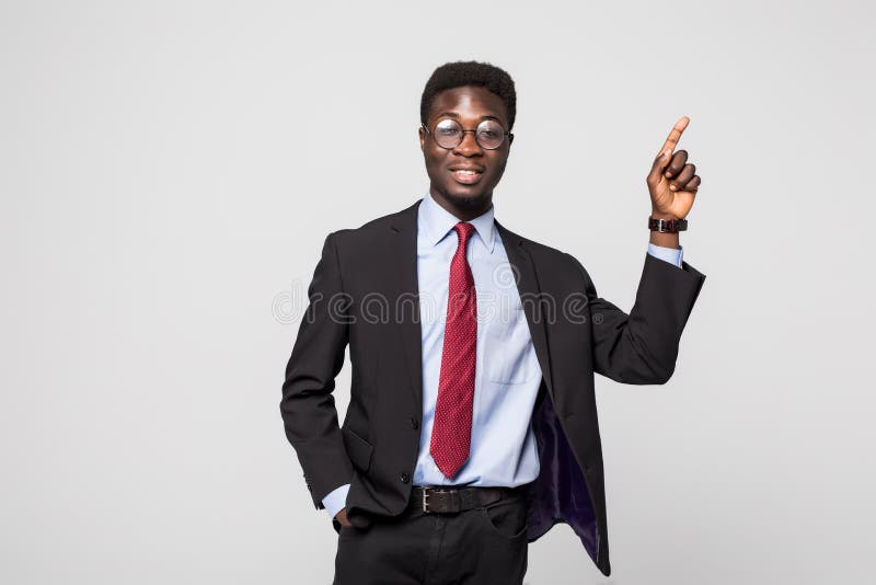 Hombre de negocios que señala en algo en fondo gris imagen de archivo Hombre de negocios que señala en algo en fondo gris imagen de archivo