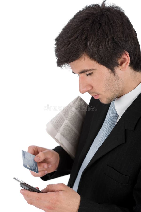 Hombre de negocios que sostiene el teléfono móvil y de la tarjeta de crédito fotografía de archivo libre de regalías Hombre de negocios que sostiene el teléfono móvil y de la tarjeta de crédito fotografía de archivo libre de regalías