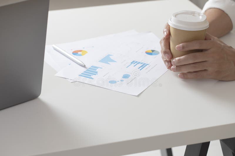 Hombre de negocios que sostiene la taza del coffe sobre cartas del tablero de instrumentos fotos de archivo libres de regalías Hombre de negocios que sostiene la taza del coffe sobre cartas del tablero de instrumentos fotos de archivo libres de regalías