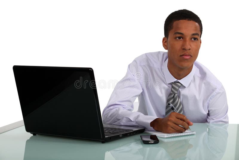 Hombre de negocios que trabaja en su escritorio imagen de archivo libre de regalías Hombre de negocios que trabaja en su escritorio imagen de archivo libre de regalías