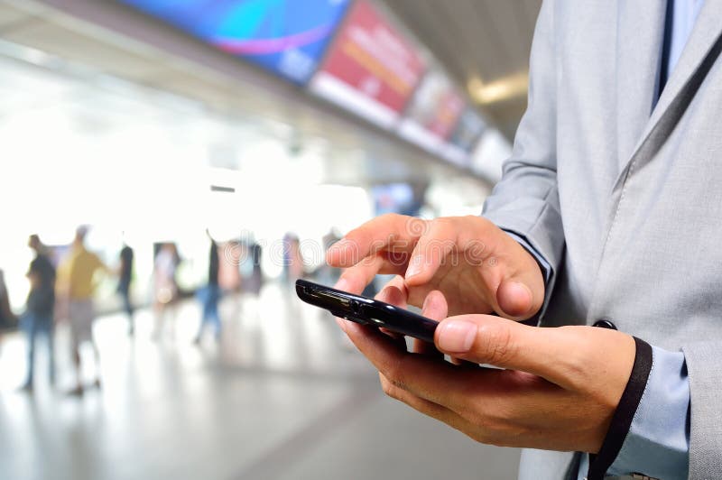 Hombre de negocios que usa el teléfono móvil en la estación de tren moderna imagen de archivo Hombre de negocios que usa el teléfono móvil en la estación de tren moderna imagen de archivo
