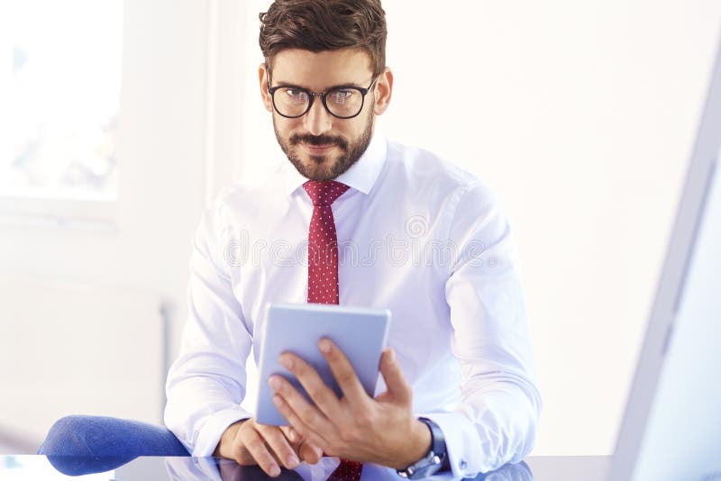 Hombre de negocios que usa la tableta digital mientras que trabaja en el escritorio de oficina fotos de archivo Hombre de negocios que usa la tableta digital mientras que trabaja en el escritorio de oficina fotos de archivo