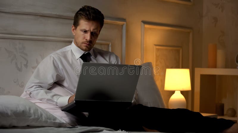 Hombre de negocios serio que prepara el discurso para encontrarse, trabajando con el ordenador en la noche fotografía de archivo Hombre de negocios serio que prepara el discurso para encontrarse, trabajando con el ordenador en la noche fotografía de archivo