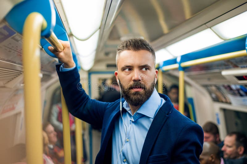 Hombre de negocios serio que viaja al trabajo Undergro interior permanente foto de archivo libre de regalías Hombre de negocios serio que viaja al trabajo Undergro interior permanente foto de archivo libre de regalías