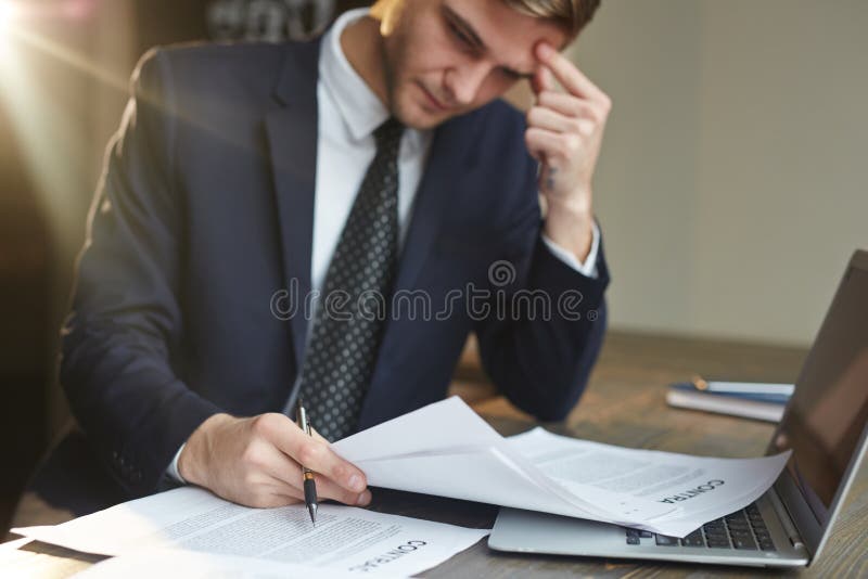 Hombre de negocios subrayado Working con los documentos del contrato fotografía de archivo libre de regalías Hombre de negocios subrayado Working con los documentos del contrato fotografía de archivo libre de regalías
