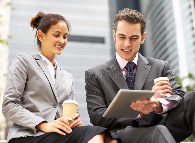 Hombre de negocios y empresaria que usa la tablilla de Digitaces foto de archivo Hombre de negocios y empresaria que usa la tablilla de Digitaces foto de archivo