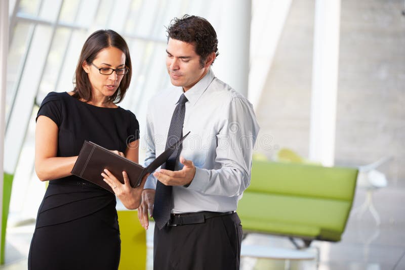 Hombre de negocios y empresarias que tienen reunión en oficina imagen de archivo Hombre de negocios y empresarias que tienen reunión en oficina imagen de archivo