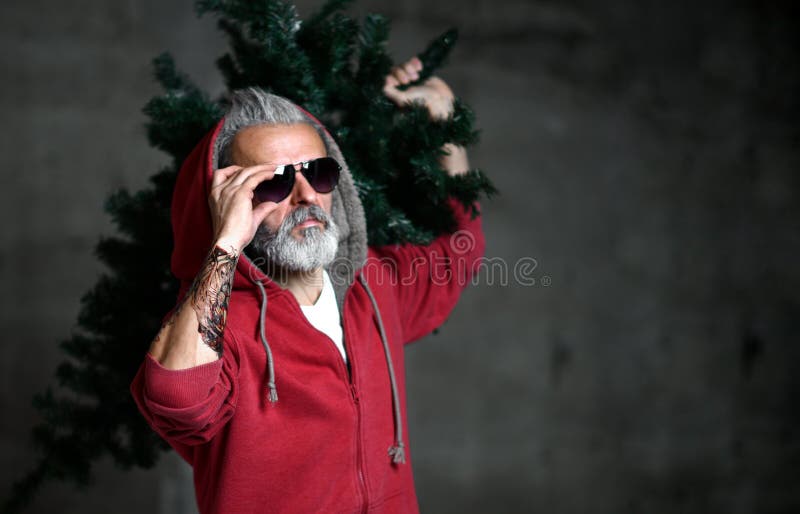 Hombre de Papá Noel del millonario moderno de moda viejo en sudadera con capucha roja de la moda celebrar la Navidad imagen de archivo libre de regalías Hombre de Papá Noel del millonario moderno de moda viejo en sudadera con capucha roja de la moda celebrar la Navidad imagen de archivo libre de regalías
