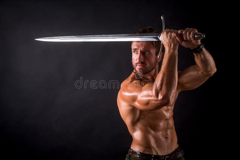 Hombre del culturista con una espada fotografía de archivo Hombre del culturista con una espada fotografía de archivo