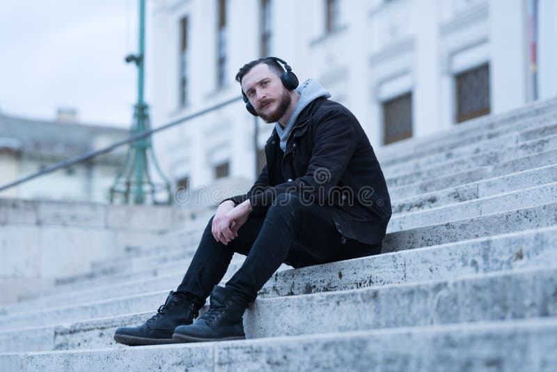 Hombre del inconformista que se sienta en las escaleras imágenes de archivo libres de regalías Hombre del inconformista que se sienta en las escaleras imágenes de archivo libres de regalías