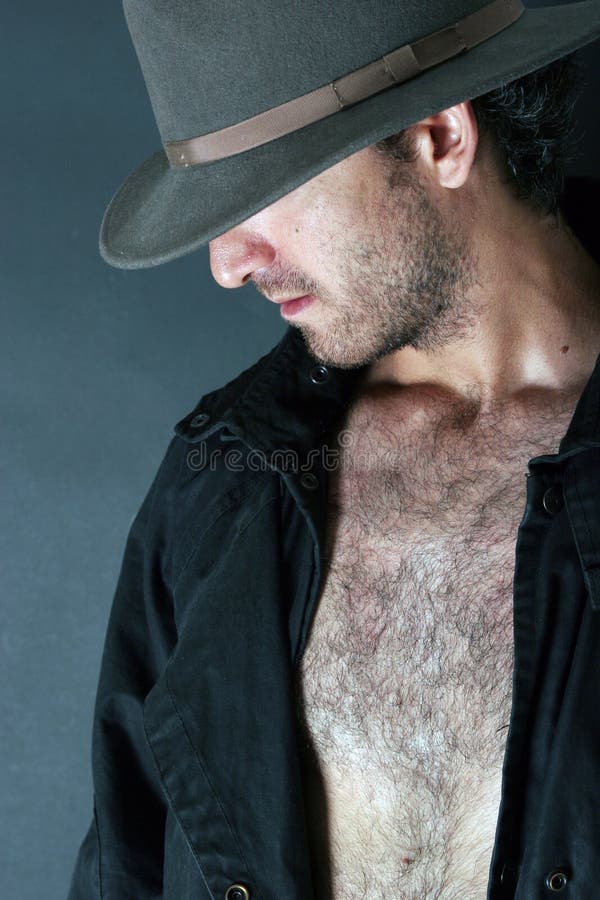 Hombre del misterio que oculta su cara bajo un sombrero fotografía de archivo Hombre del misterio que oculta su cara bajo un sombrero fotografía de archivo