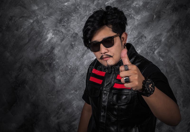 Hombre del motorista en chaqueta de cuero negra con el pulgar para arriba fotos de archivo Hombre del motorista en chaqueta de cuero negra con el pulgar para arriba fotos de archivo