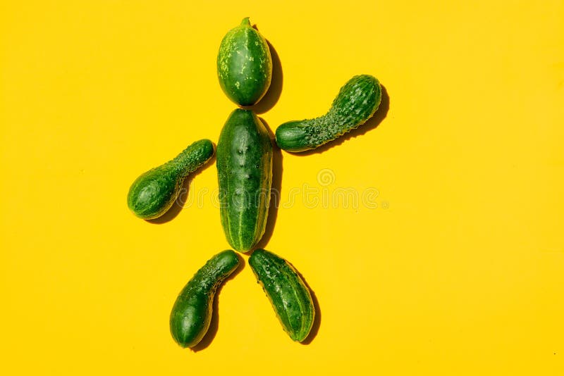 Hombre del pepino en un fondo amarillo Figura del hombre hecha de los pepinos fotos de archivo Hombre del pepino en un fondo amarillo Figura del hombre hecha de los pepinos fotos de archivo