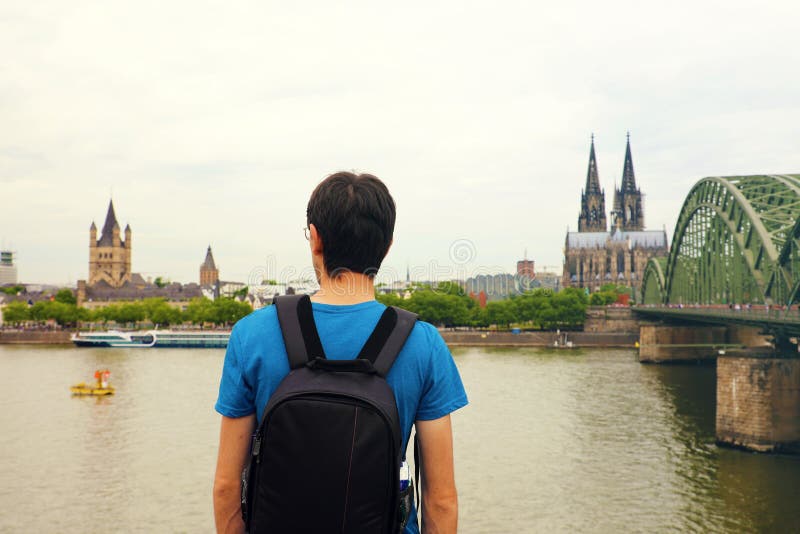 Hombre del viajero que disfruta de su día de fiesta en Europa Vista posterior del backpacker masculino que mira a la ciudad de Co foto de archivo Hombre del viajero que disfruta de su día de fiesta en Europa Vista posterior del backpacker masculino que mira a la ciudad de Co foto de archivo
