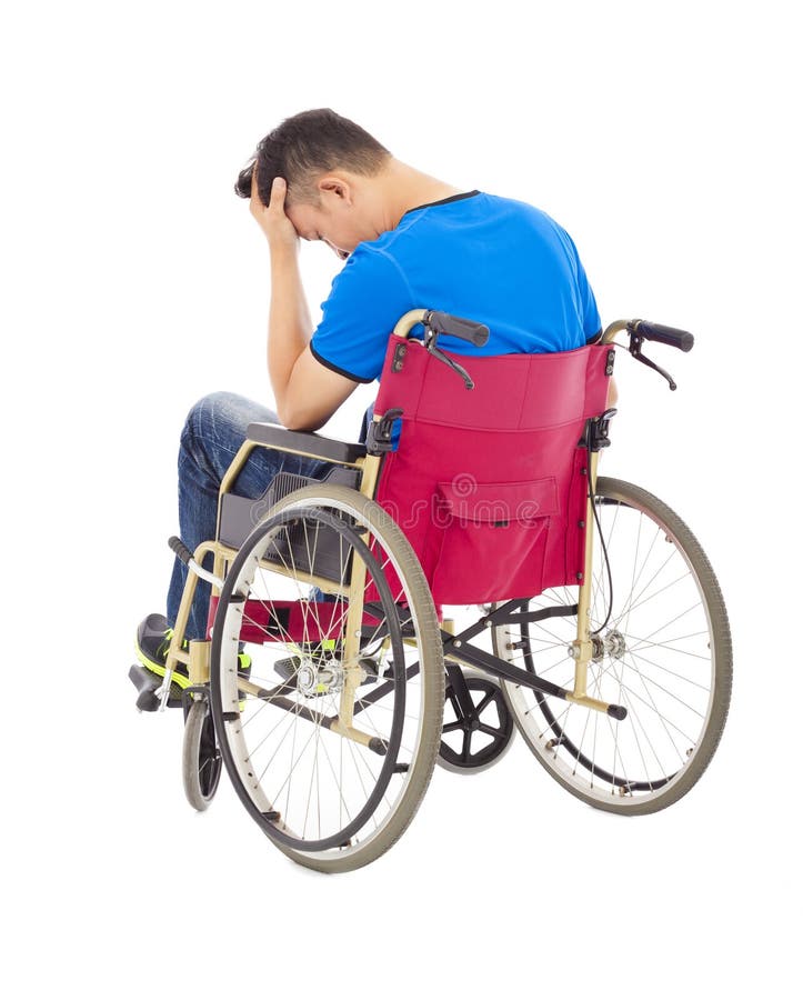 Hombre deprimido y perjudicado que se sienta en una silla de ruedas fotografía de archivo Hombre deprimido y perjudicado que se sienta en una silla de ruedas fotografía de archivo