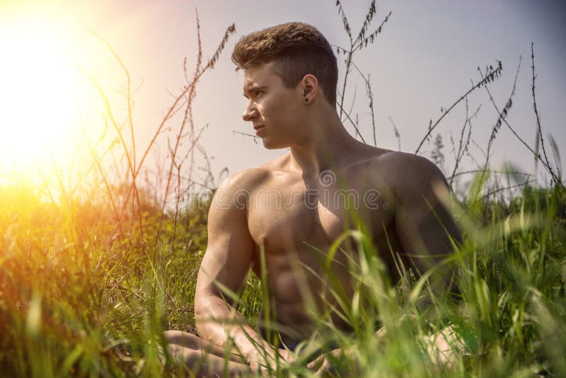 Hombre descamisado muscular joven del trozo al aire libre en naturaleza foto de archivo libre de regalías Hombre descamisado muscular joven del trozo al aire libre en naturaleza foto de archivo libre de regalías