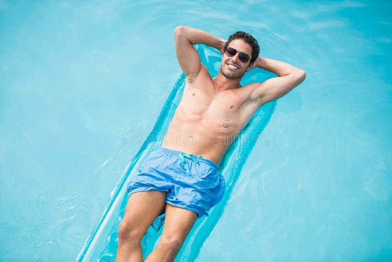 Hombre descamisado que se relaja en balsa inflable fotografía de archivo libre de regalías Hombre descamisado que se relaja en balsa inflable fotografía de archivo libre de regalías