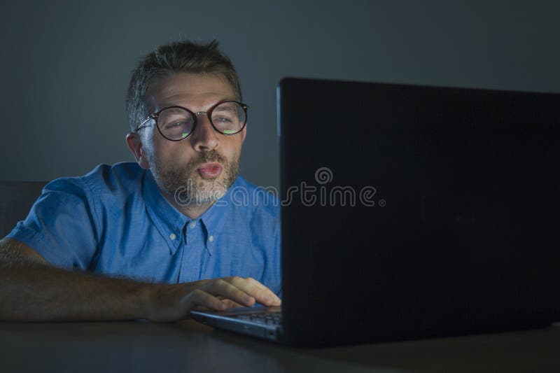 Hombre despertado lascivo del adicto a la pornografía en vidrios del empollón que mira la película del sexo en línea de última ho foto de archivo libre de regalías Hombre despertado lascivo del adicto a la pornografía en vidrios del empollón que mira la película del sexo en línea de última ho foto de archivo libre de regalías
