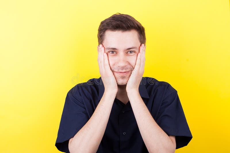 Hombre emocionado con las manos en su cara sobre fondo amarillo fotografía de archivo libre de regalías Hombre emocionado con las manos en su cara sobre fondo amarillo fotografía de archivo libre de regalías